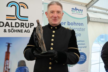 Mann in Bergmannskluft mit Barbarafigur in der Hand